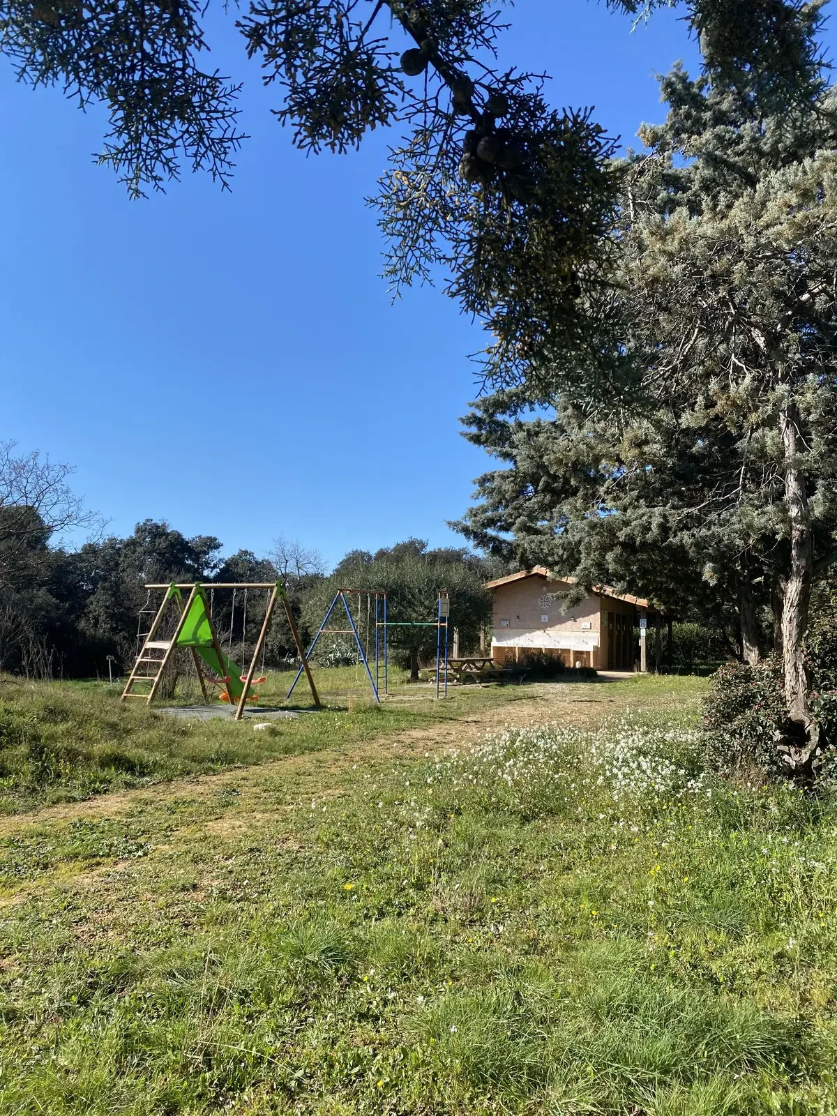 Aire de jeux et bâtiment sanitaire en journée